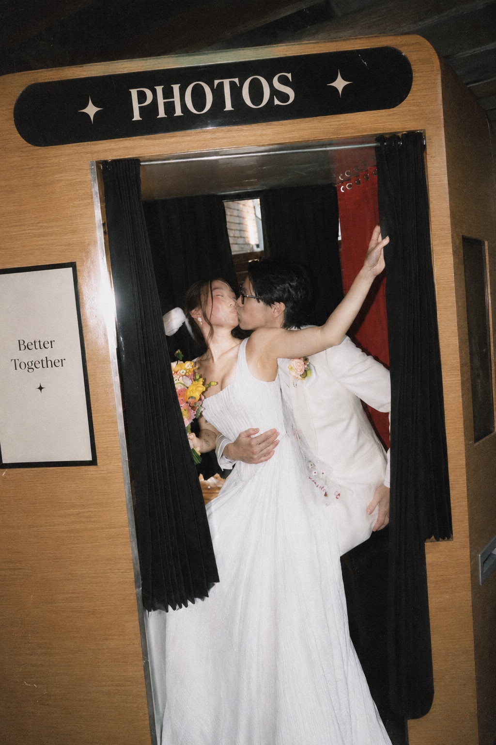 Newlyweds laughing as they step into the booth